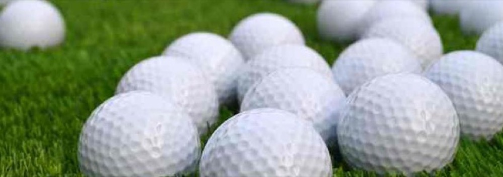 White practice golf balls on turf